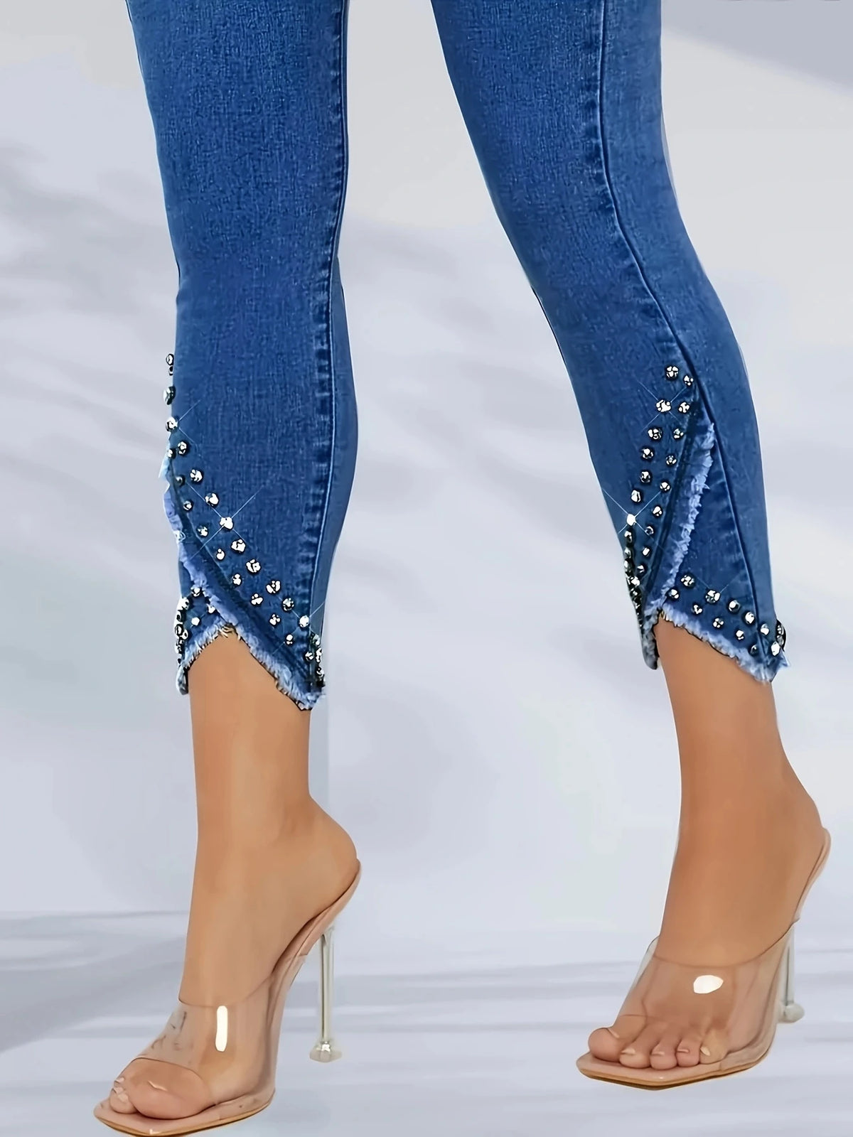 High-waisted fashionable straight-leg jean with irregular hem and frayed edges; sequin-studded skinny jeans
