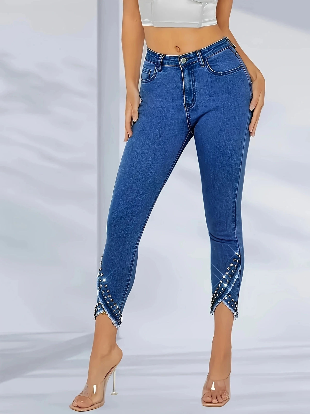 High-waisted fashionable straight-leg jean with irregular hem and frayed edges; sequin-studded skinny jeans