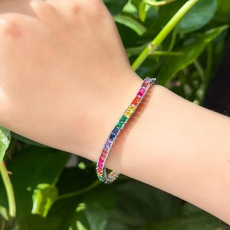 A dazzling 14K gold tennis bracelet adorned with rainbow-shaped cubic zirconia, the perfect gift for special occasions.