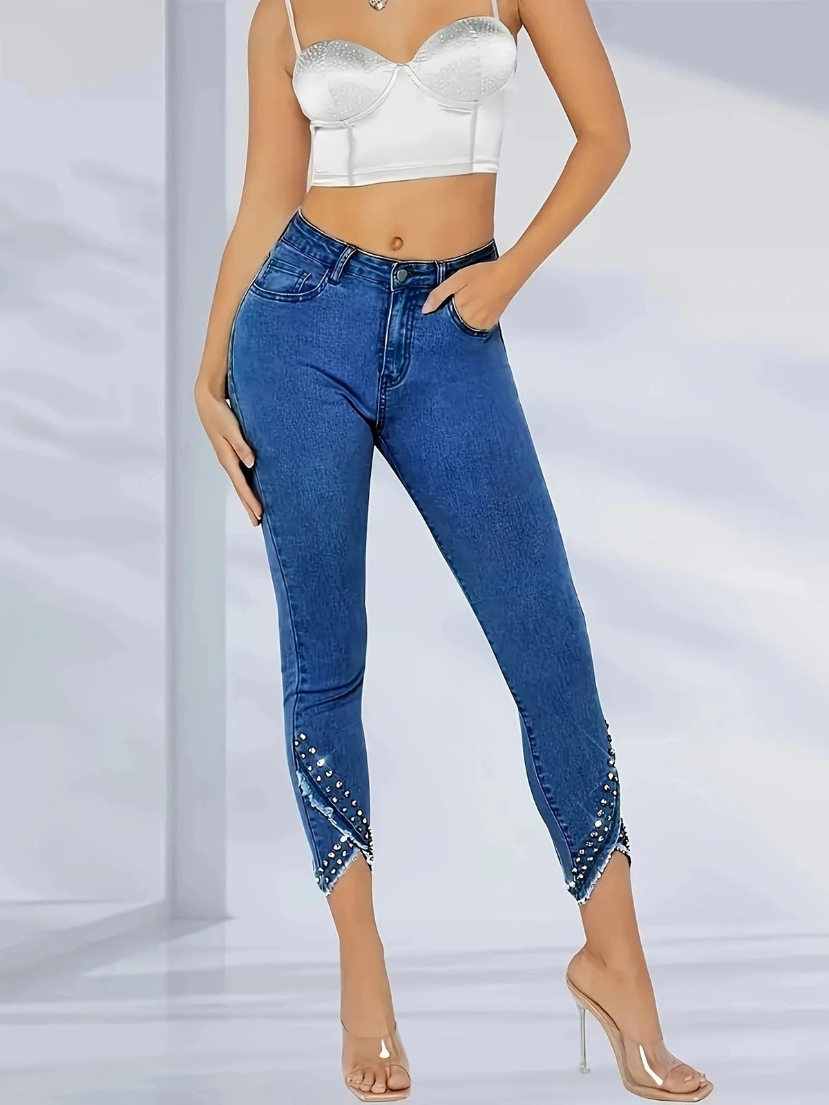 High-waisted fashionable straight-leg jean with irregular hem and frayed edges; sequin-studded skinny jeans